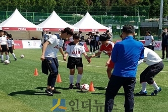 손흥민 선수가 장애 아동에게 드리블을 가르쳐주는 모습.