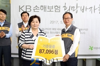 양종희 KB손보 대표이사 사장(오른쪽)이 아름다운가게 홍명희 이사장(왼쪽)에게 8만 7000점의 기부물품을 상징하는 보드판을 전달하고 있다.