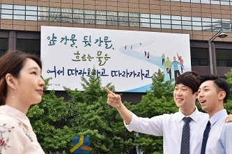 29일, 시민들이 교보생명 광화문글판 ‘여름편’이 내걸린 광화문 교보생명빌딩 주변을 걷고 있다.