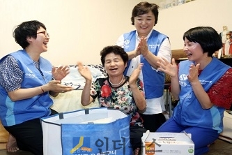 지난 21일, 봉사자들이 서울 중구 약수동에 거주하는 독거노인 가정에서 여름나기 물품이 담긴 ‘하하하 웃음 바구니’를 전달한 후 함께 웃음체조를 하고 있다.