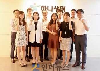 하나생명 상품담당 임원인 주재중 전무(사진 왼쪽에서 5번째)와 상품개발부 직원들이 파이팅을 외치고 있다.