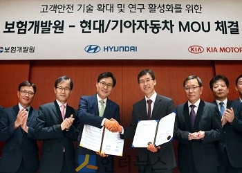 김헌수 현대자동차 고객안전전략사업부 부사장(사진 가운데 오른쪽)과 권흥구 보험개발원 부원장(사진 가운데 왼쪽)이 업무 협약서에 사인한 뒤 악수를 나누고 있다.