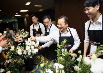 김현철 한화생명 전략기획실장(사진 오른쪽에서 두번째) 및 임원들과 신입사원들이 결혼식에 쓸 꽃 장식을 준비하고 있다.