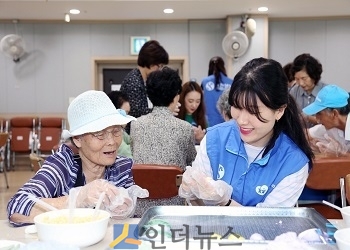 신한생명 직원봉사자가 어르신과 송편을 만들면서 대화를 나누고 있다.