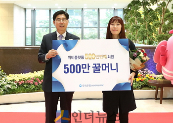 이광구 우리은행장(사진 왼쪽)이 500만번째 가입 고객과 기념촬영을 하고 있다.