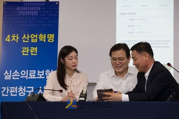 31일 서울 여의도 보험개발원에서 개최된 실손보험 간편청구 시연회에서 최종구 금융위원장(가운데)과 김연아 전 국가대표 피겨 선수가 실손보험 간편청구 앱을 직접 시연하고 있다.(출처: 금융위)