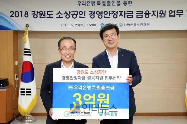 이창재 우리은행 부행장(사진 오른쪽)이 이남규 강원신용보증재단 이사장과 기념촬영을 하고 있다.