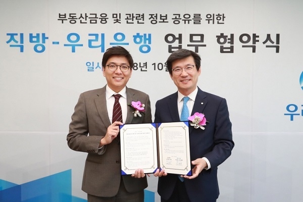12일 우리은행 본점에서 진행된 업무 협약식에서 이창재 우리은행 부동산금융그룹 부행장(사진 오른쪽)이 안성우 직방 대표이사와 기념촬영을 하고 있다.