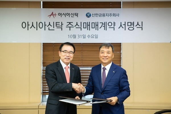 31일 진행된 주식매매계약 체결식에서 조용병 신한금융 회장(사진 왼쪽)과 정서진 아시아신탁 부회장이 기념 촬영을 하고 있다.