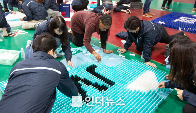 행사에 참가한 대한항공과 델타항공 직원들이 도미노를 쌓고 있는 모습 (사진제공 : 대한항공)