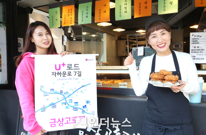 LG유플러스 직원(좌측)과 서촌마을 고로케 판매점 ‘금상고로케’ 이양옥 사장(우측)이 ‘U<sup>+</sup>로드’를 알리는 모습 (사진제공 : LG유플러스)