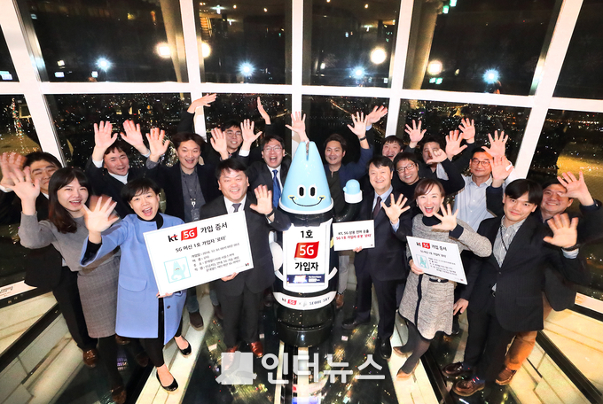 1일 KT 5G 머신 1호 가입자인 인공지능 로봇 ‘로타’가 KT 관계자들과 함께 환호하고 있다. (사진제공 : KT)