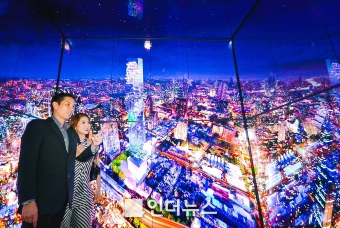 태국 최고층 건물인 마하나콘 타워의 전망대 전용 엘리베이터 탑승객들이 내부 4면을 둘러싼 LG 올레드 사이니지를 통해 방콕의 모습을 감상하고 있다. (사진 제공 : LG전자)
