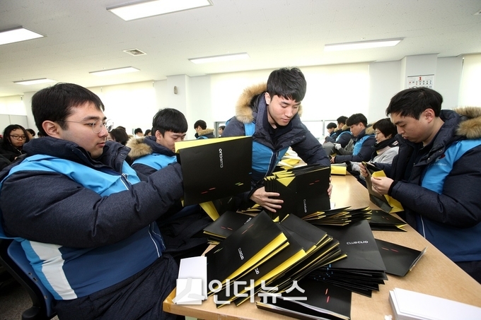 대우건설 신입사원들이 지난 9일 홀트일산복지타운에 방문해 장애인들이 봉투를 만드는 작업을 돕고 있다. (사진 : 대우건설)