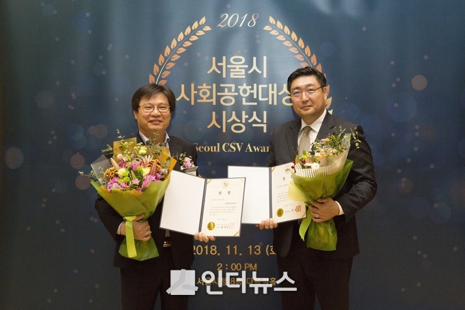 현대건설 서완석 총무실장(오른쪽)과 종로종합사회복지관 이재원 관장(왼쪽)이 ‘2018 서울시 사회공헌 대상’을 수상한 후 함께 기념 사진을 촬영하고 있다. (사진 : 현대건설)