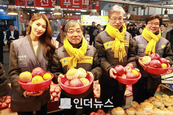 23일 서울 양천구 신영시장에서 열린 ‘전통시장 사랑나눔’ 행사에서 참석자들이 과일 바구니를 들고 있다. (왼쪽부터)김정화 기아대책 홍보대사, 윤석헌 금감원장, 허인 KB국민은행장, 유원식 기아대책 회장.