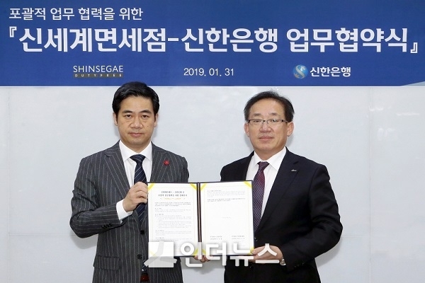 신한은행은 31일 서울 중구 세종대로 소재 본점에서 신세계면세점과 포괄적 업무협약을 체결했다. 협약식을 마치고 이승렬 외환사업본부장(오른쪽)과 만성원 신세계면세점 상무가 기념촬영 하는 모습. Photo@신한은행 
