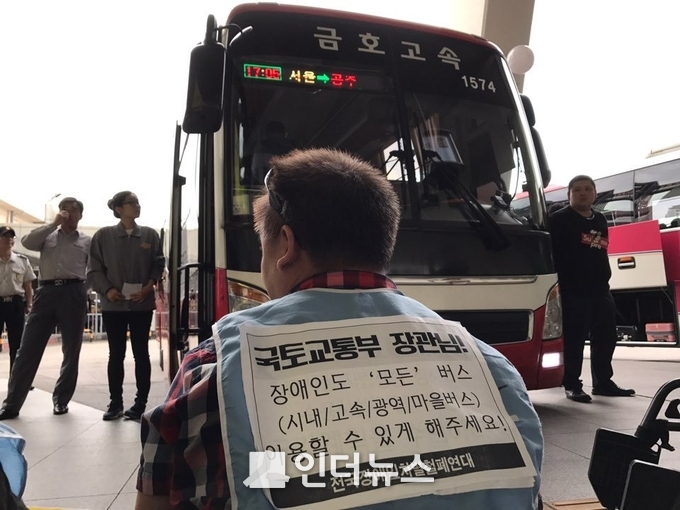 지난 2017년 9월 전국장애인차별철폐연대 소속 장애인 한 명이 등에 ’장애인도 모든 버스 이용할 수 있게 해주세요’라는 피켓을 붙이고 시위에 나서고 있다. photo@전국장애인차별철폐연대