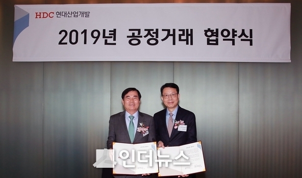 김대철 HDC현대산업개발 사장(오른쪽)과 정달홍 성보엔지니어링 대표이사(왼쪽)가 공정거래협약서 교환 후 기념사진을 촬영하고 있다. Photo @ HDC현대산업개발