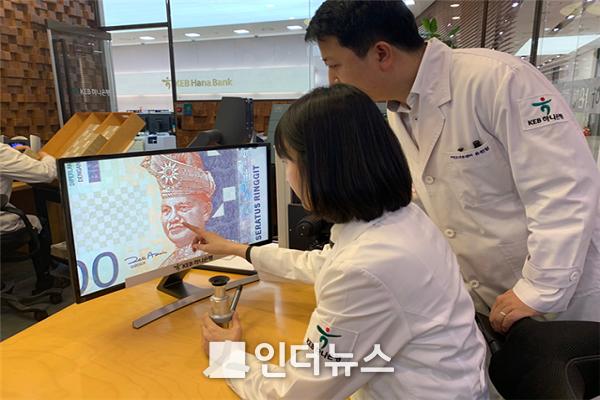 KEB하나은행 위변조대응센터 직원들이 전문장비로 말레이시아 화폐를 감정하고 있다. Photo @ KEB하나은행