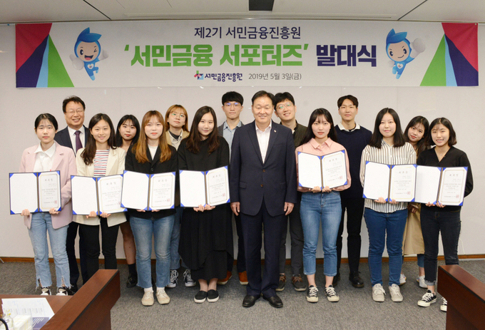 이계문 서민금융진흥원 원장(가운데)과 최건호 부원장(왼쪽 두 번째)이 3일 진흥원에서 열린 ‘서민금융 서포터즈’ 발대식에서 서포터즈로 위촉된 대학생 16명과 기념촬영을 하고 있다. Photo @ 서민금융진흥원