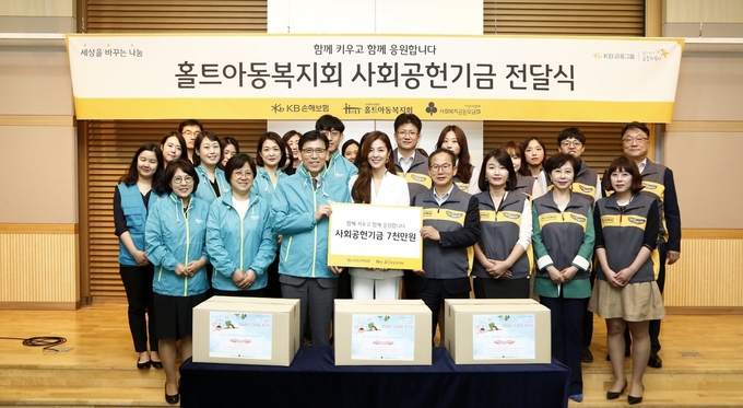 지난 20일 미혼모 아동들의 건강한 성장을 돕기 위해 열린 기부 협약식·사회공헌기금 전달식에 참석한 양종희 KB손해보험 사장(첫번째줄 오른쪽에서 네번째), 김호연 홀트아동복지회 회장(첫번째줄 오른쪽에서 여섯번째), 김성은 홍보대사(첫번째줄 오른쪽에서 다섯번째)가 임직원 봉사단원들과 함께 기념 촬영을 하고 있다. Photo @ KB손해보험
