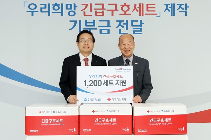 지난달 31일 서울 중구 우리금융그룹 본점에서 열린 '우리희망 긴급구호세트' 제작 기부금 전달식에 참석한 손태승 우리금융그룹 회장(왼쪽)과 박경서 대한적십자사 회장이 기념촬영을 하고 있다. Photo @ 우리은행