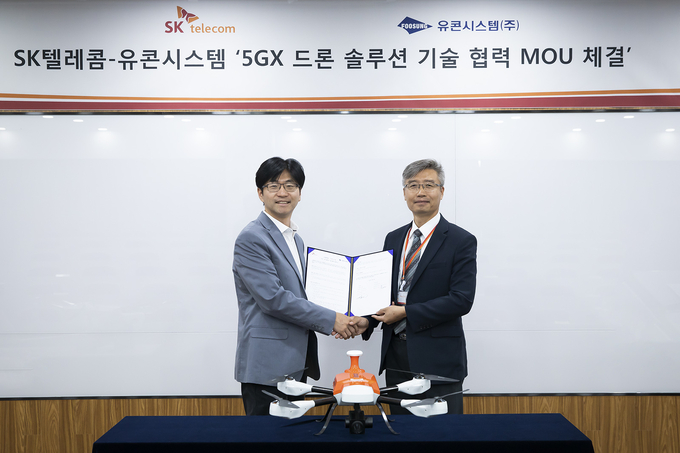 SK텔레콤은 무인항공기 개발사 유콘시스템과 SK텔레콤 분당사옥에서 ‘5GX 드론 솔루션 개발’을 위한 업무 협약을 체결했다고 3일 밝혔다. 사진은 협약식에 참석한 SK텔레콤 김경남 시큐리티랩스장(왼쪽)과 유콘시스템 송재근 대표(오른쪽).