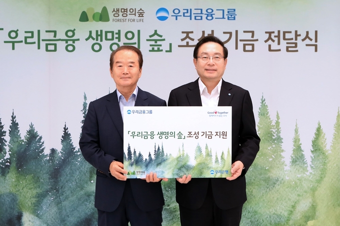 우리금융그룹은 지난 3일 서울시 중구 우리은행 본점에서 ‘우리금융 생명의 숲’ 조성 기금 전달식을 가졌다. 손태승 우리금융그룹 회장(사진 오른쪽)이 허상만 사단법인 생명의 숲 이사장과 기념 촬영을 하고 있다. Photo @우리은행