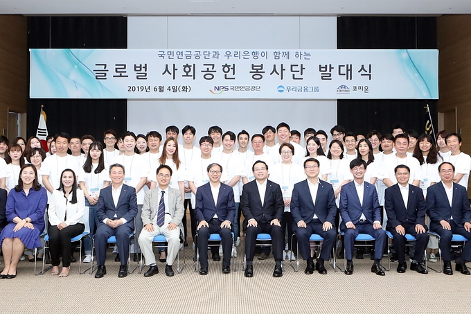 우리금융그룹은 지난 4일 전북 전주 국민연금공단 본부에서 우리금융그룹과 국민연금공단 직원 50여명으로 구성된 ‘글로벌 사회공헌 봉사단’ 발대식을 가졌다. 글로벌 봉사단은 오는 16일부터 21일까지 캄보디아에서 봉사활동을 수행한다. 손태승 우리금융그룹회장 및 우리은행장(앞줄 오른쪽에서 다섯째)과 김성주 국민연금공단 이사장(앞줄 오른쪽에서 여섯째)이 봉사자들과 기념촬영을 하고 있다. Photo @ 우리금융
