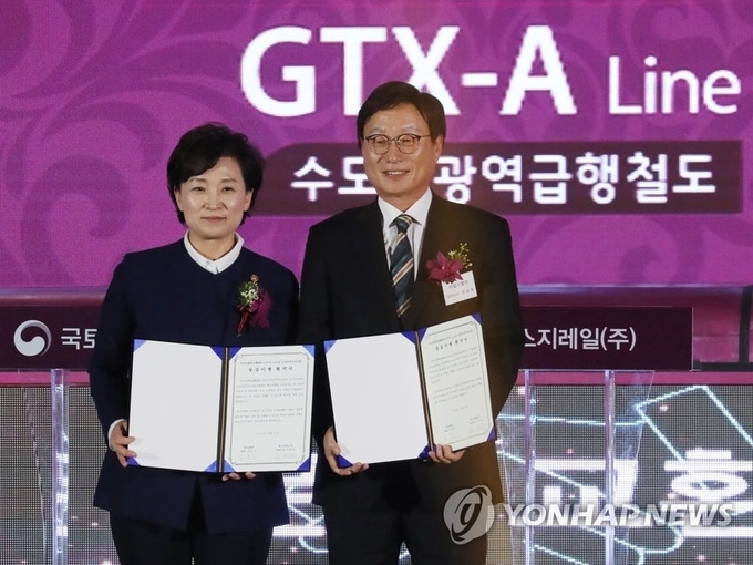 작년 12월 김현미 국토교통부 장관(왼쪽)이 GTX A노선 착공식에서 사업 시행자인 전병훈 에스지레일 주식회사 대표이사와 기념촬영하고 있다. Photo ⓒ 연합뉴스