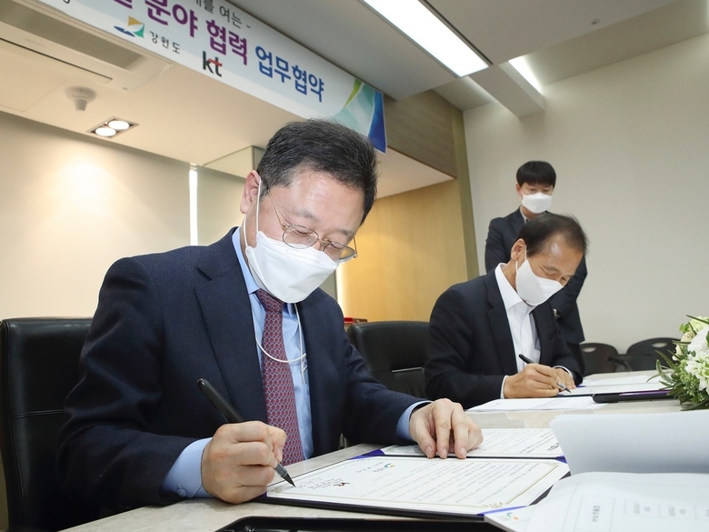 KT Enterprise부문 신수정 부문장(왼쪽)과 강원도 최문순 도지사가 MOU에 서명을 하고 있는 모습. 사진ㅣKT
