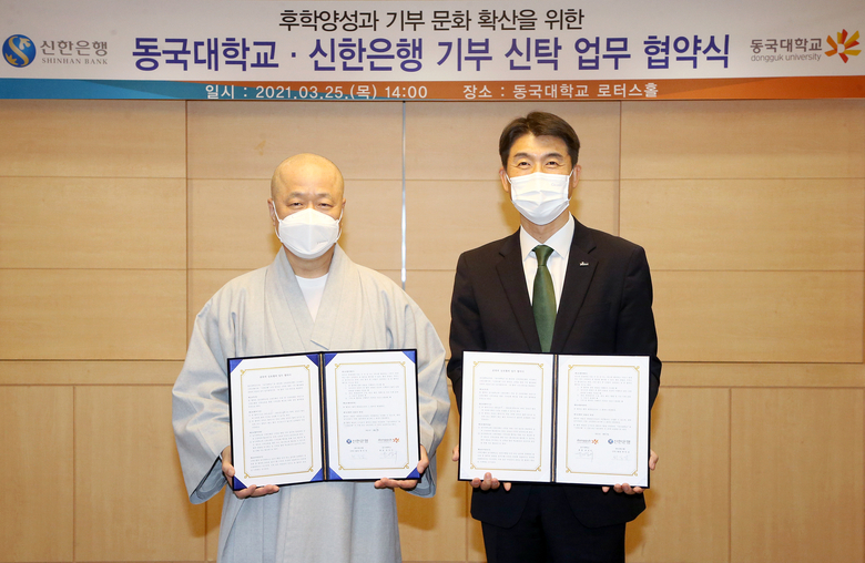 지난 25일 서울 중구에 위치한 동국대학교에서 가진 ‘동국대학교-신한은행 기부 신탁 업무 협약식’ 에서 최익성 신한은행 그룹장(오른쪽)과 종호 동국대학교 기획부총장 스님(왼쪽)이 협약식을 마치고 기념촬영을 하고 있습니다. 사진ㅣ신한은행
