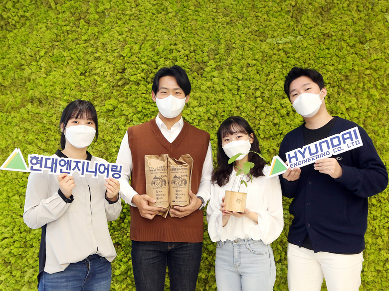‘집에서 씨앗 키우는 통나무(이하 집씨통)’에 참여하는 현대엔지니어링 직원들이 도토리 씨앗이 들은 나무화분을 들고 있다. 사진ㅣ현대엔지니어링