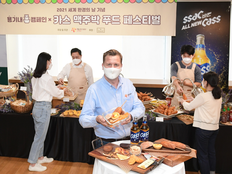 오비맥주 배하준 대표(가운데)가 강남구 오비맥주 본사에서 2일 개최한 ‘카스 맥주박 업사이클링 푸드 페스티벌’에서 직접 챙겨온 용기에 맥주박 푸드를 담고 기념 촬영을 하고 있습니다. 사진ㅣ오비맥주