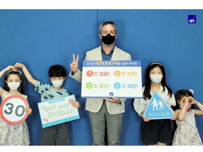  질 프로마조 AXA손해보험 대표(가운데)가 임직원들 자녀들과 함께 ‘어린이 교통안전 챌린지’에 동참해 기념촬영을 진행했습니다. 사진ㅣAXA손해보험