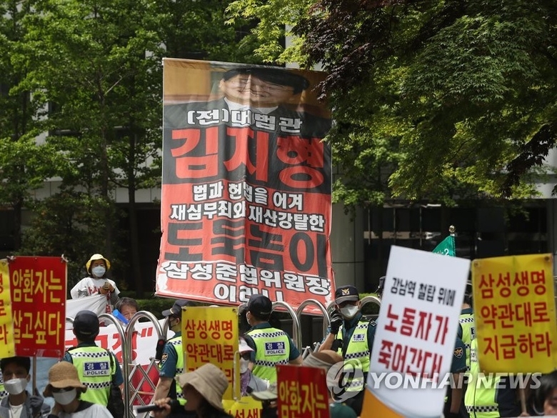 지난해 5월 서초동 성생명 사옥 앞에서 기습시위를 벌이는 삼성해고노동자 고공농성 공대위와 보험사에 대응하는 암환우 모임. 사진ㅣ연합뉴스