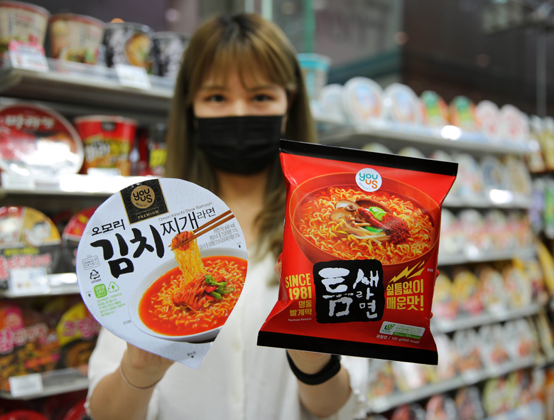 모델이 친환경 포장재로 만든 오모리김치찌개 라면과 틈새라면을 들고 포즈를 취하고 있습니다. 사진ㅣGS리테일