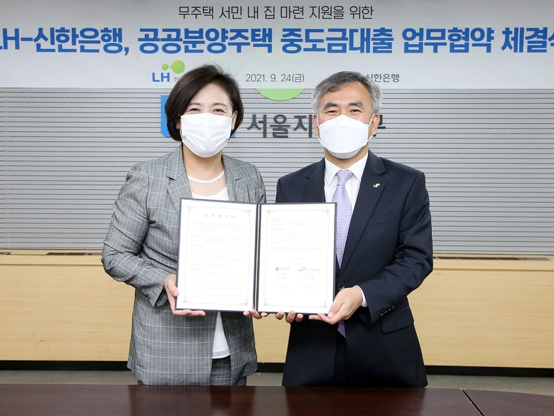 서울시 강남구 소재 LH서울지역본부에서 열린 신한은행과 LH의 공공분양주택 중도금대출 업무협약식에서 조경선 신한은행 부행장(왼쪽)과 이정관 한국토지주택공사 부사장이 기념촬영하는 모습. 사진ㅣ신한은행