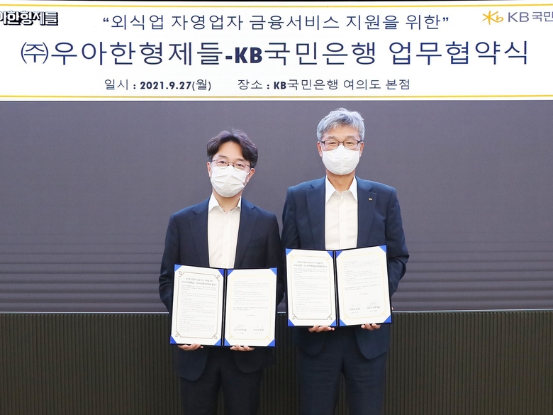27일 KB국민은행 여의도 본점에서 열린 외식업 자영업자 금융서비스 지원을 위한 KB국민은행-(주)우아한형제들 업무 협약식에서 (오른쪽)허인 KB국민은행장과 (왼쪽)김범준 우아한형제들 대표이사가 업무협약을 체결하고 기념촬영을 하고 있는 모습. 사진ㅣKB국민은행