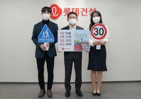 롯데건설 하석주 대표이사(가운데)와 임직원들이 20일 서초구 잠원동에 위치한 본사에서 '어린이 교통안전 릴레이 캠페인'에 참여하고 있는 모습 사진ㅣ롯데건설