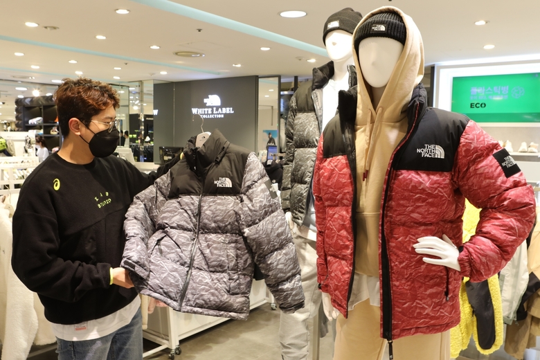 박주호 롯데백화점 스포츠 바이어가 매장에 진열된 '노벨티 눕시' 패딩을 살펴보는 모습. 사진ㅣ롯데쇼핑