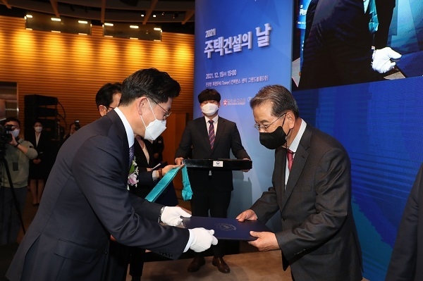 노형욱 국토교통부 장관(사진 왼쪽)이 권혁운 아이에스동서 회장(사진 오른쪽)에게 금탑산업훈장을 수여하고 있다. 사진ㅣ대한주택건설협회 제공