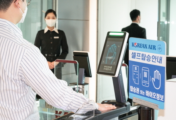 김포공항 탑승구 앞에서 승객이 '바이오 셀프보딩 서비스'를 이용하고 있는 모습. 사진│대한항공