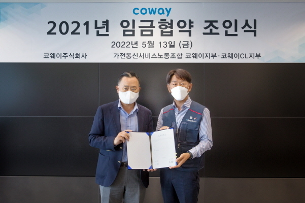 이해선 코웨이 부회장(왼쪽)과 이현철 전국가전통신서비스 노동조합 위원장(오른쪽)이 임금협약서 서명 후 사진 촬영을 하고 있다. 사진│코웨이