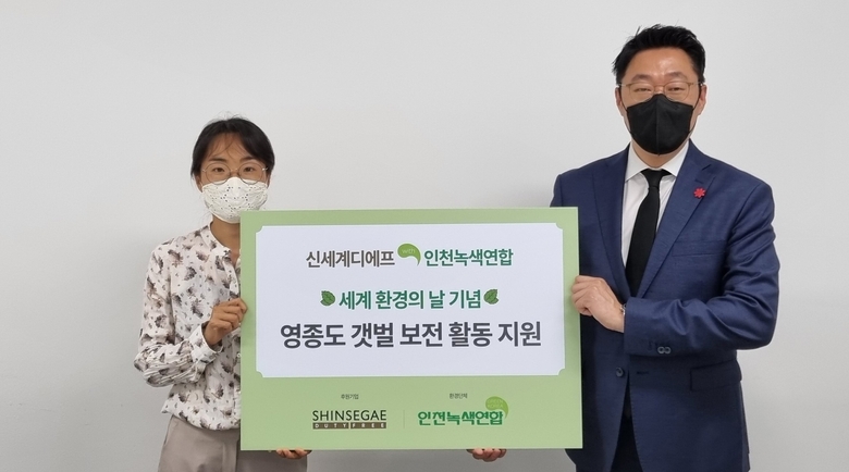 영종도 갯벌보전 활동 지원금 전달 모습. 박주희 인천녹색연합 사무처장(왼쪽)과 곽종우 신세계면세점 인천공항점장(오른쪽). 사진ㅣ신세계면세점