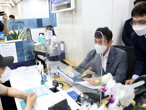 이복현 금융감독원장이 14일 서울 중구 소재 신한은행 남대문지점에서 일일 창구직원 역을 맡아 고객과 상담하고 있다. 사진ㅣ금융감독원