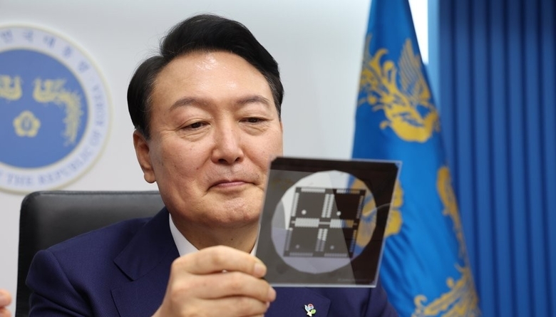 윤석열 대통령이 지난 6월7일 서울 용산 대통령실 청사에서 열린 국무회의에서 이종호 과학기술정보통신부 장관에게 받은 반도체 포토마스크를 살펴보는 모습. 사진|연합뉴스