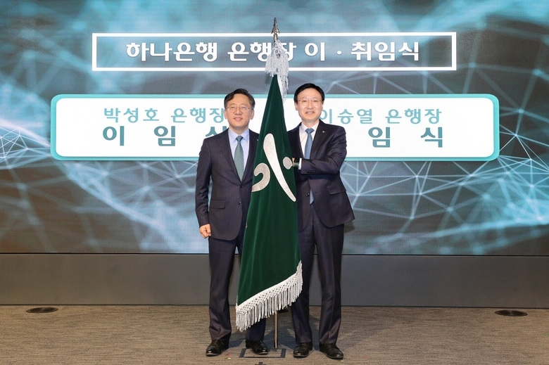 2일 하나은행장 이취임식에서 이승열 신임 하나은행장(오른쪽)이 박성호 전임 하나은행장으로부터 은행기를 전달받는 모습. 사진|하나은행