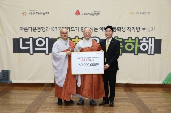 9일 'KB국민카드 예비초등학생 책가방 보내기 기부금 전달식'에서 이창권 KB국민카드 사장(오른쪽)이 아름다운동행 이사장 진우스님(가운데), 상임이사 일화스님과 기념촬영하는 모습. 사진│KB국민카드
